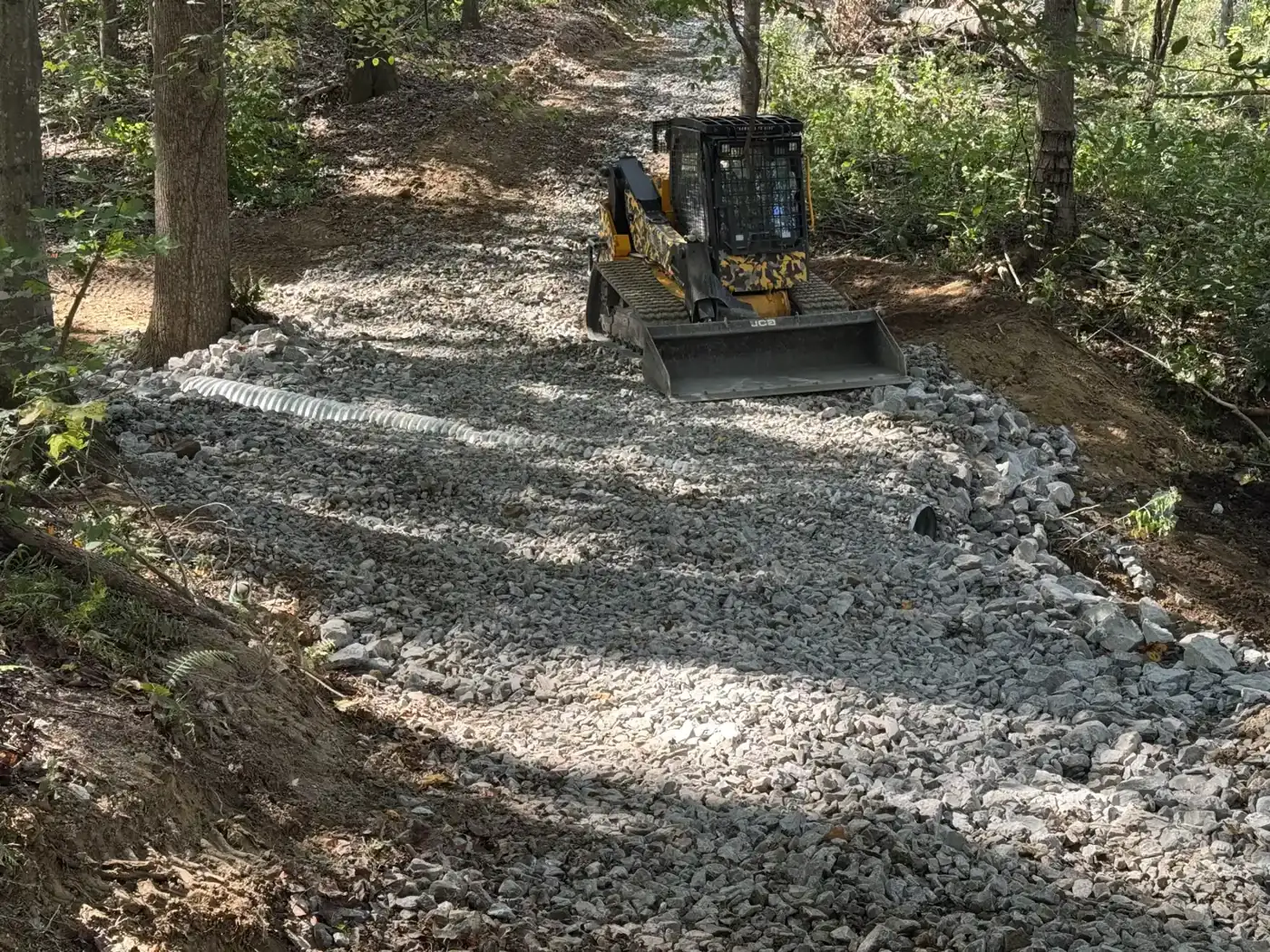 The Bigfoot rig spreading fresh gravel over the new culvert on a woods road in Westmoreland, TN